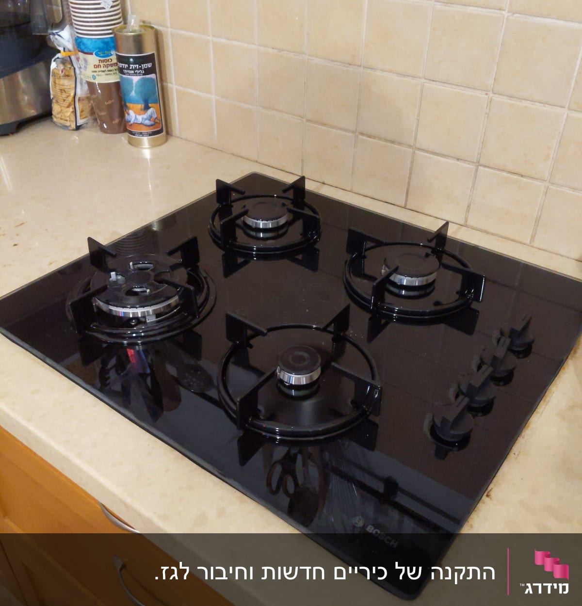 כיריים גז שחורות עם ארבעה מבערים וכפתורים